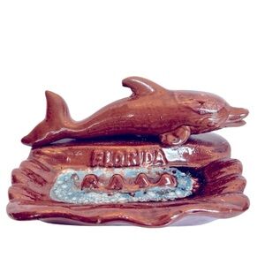 Vintage Ceramic Florida Ashtray with a Brown Dolphin Swimming in Blue Water.